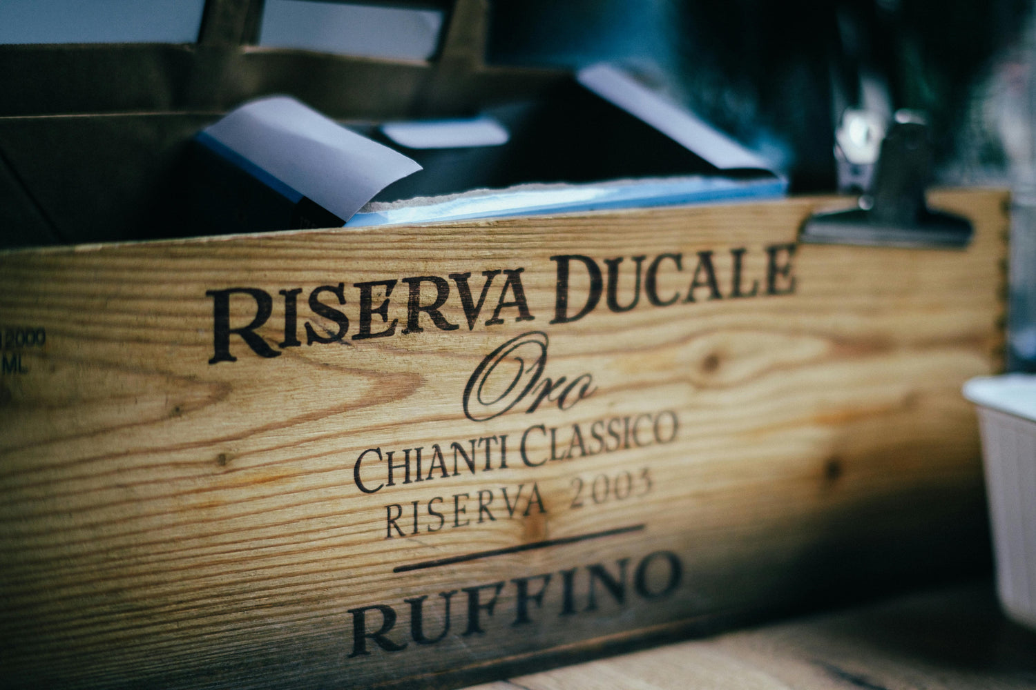 Wooden wine box with 'Riserva Ducale' branding on a blurred background